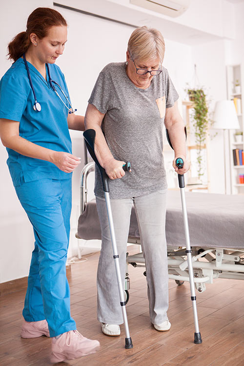 Woman on crutches being helped by a nurse
