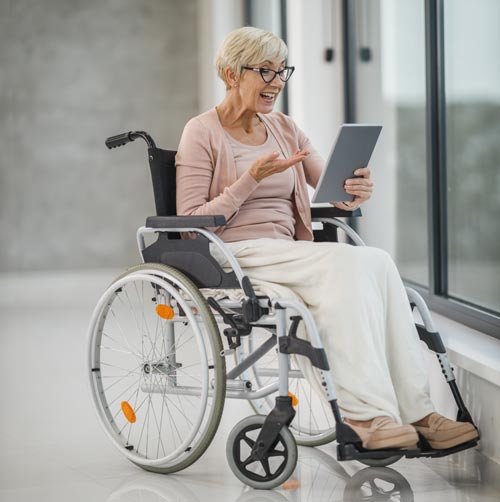 Woman in a wheelchair holding a tablet for a video call