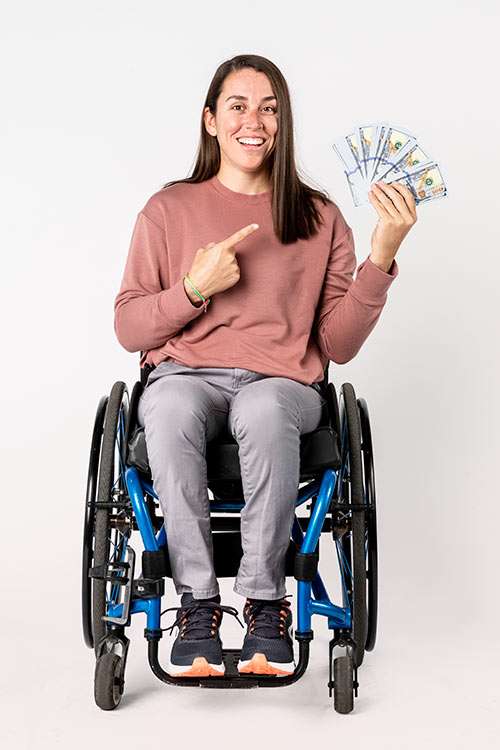 Happy woman with a disability sitting in a wheelchair holding the money her DI policy paid out