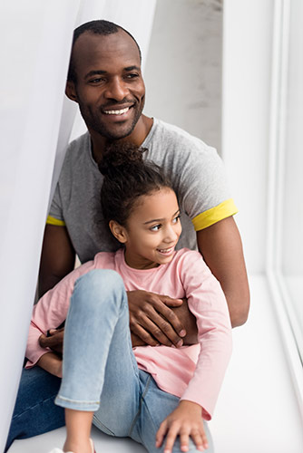 Client Barry sitting with his daughter on her bed