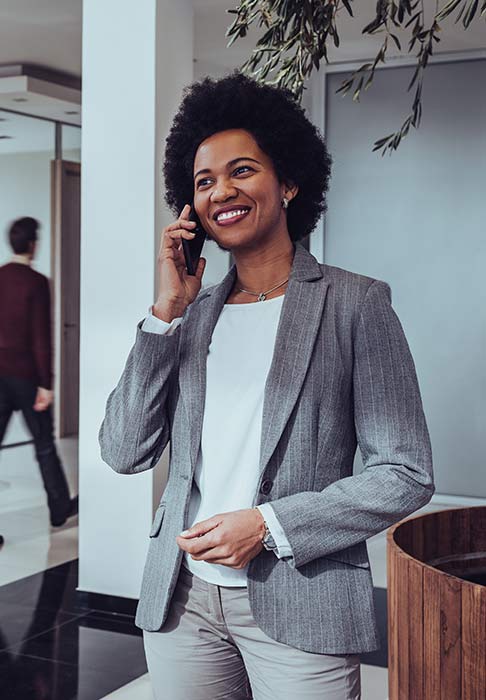 Woman in a business suit on the phone in her busy office