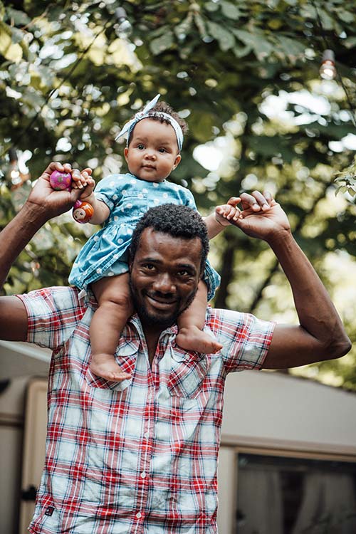 Client Darryl with his daughter on his shoulders