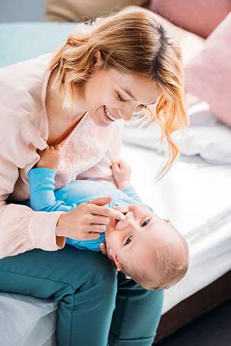 Mother smiling and playing with her baby