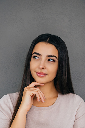 Woman thinking, with her finger propped beneath her chin