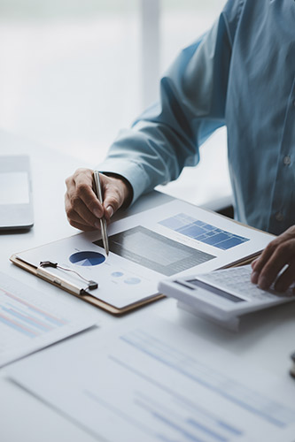 Photo of a man using a calculator while looking at a pie chart of stock returns