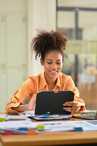 Young Black woman researching variable universal life insurance on her laptop