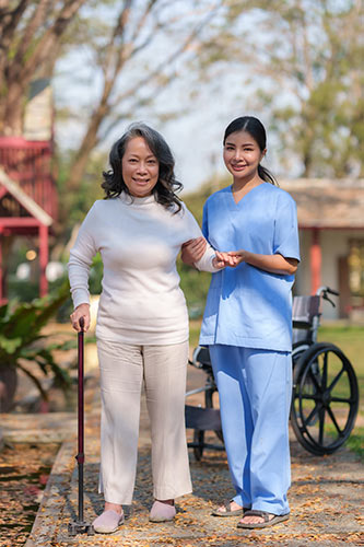 Older woman getting help from a nurse as she recovers from a disability thanks to disability insurance