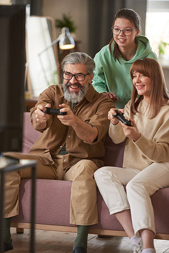 Parents playing video games with their teenage daughter