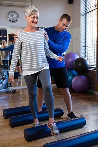 Woman with disability insurance getting help with physical therapy from a trainer