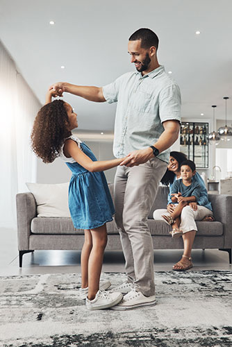Father dancing with his daughter in the living room