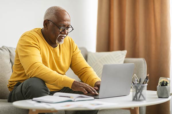 Senior man using his laptop to search for answers to the question, ‘How much term life insurance do I need?’