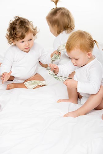 Three toddler girls holding dollar bills, symbolizing the potential to use whole life insurance cash value to pay for college