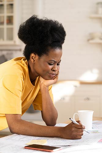 Woman making a list of all the expenses she wants her term life insurance policy to cover for her kids