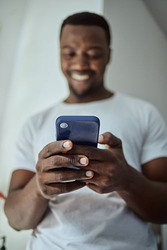 Man using his smartphone to get a policy loan to borrow from his permanent life insurance policy