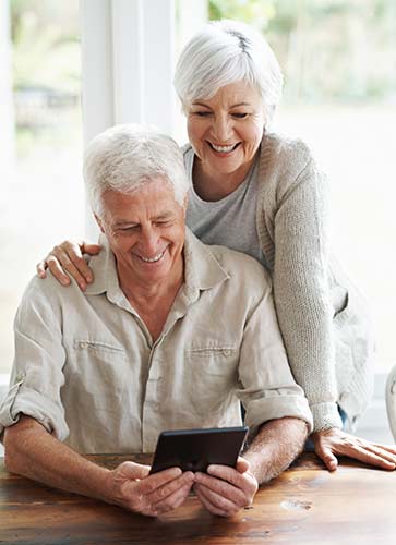 Senior couple looking for affordable term life insurance on a tablet