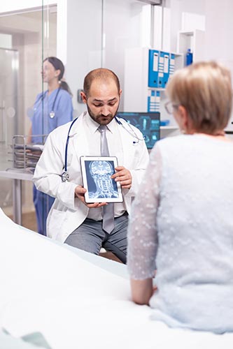 Doctor explaining a short term injury to his patient using an x-ray on a tablet