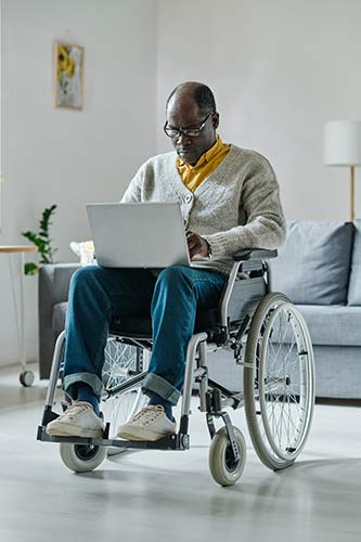 Man searching for what is considered disability on his laptop to see if he can submit a claim to his insurer