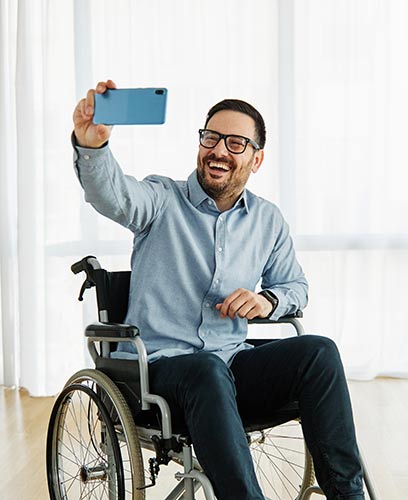 Man with a short-term disability in a wheelchair taking a selfie