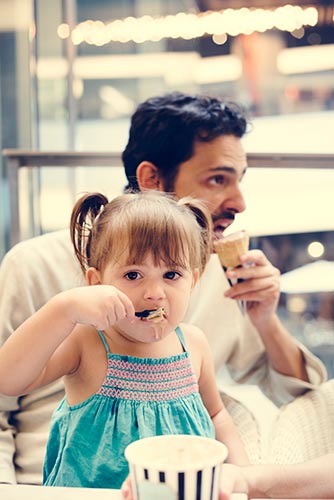 Father and daughter eating ice cream together