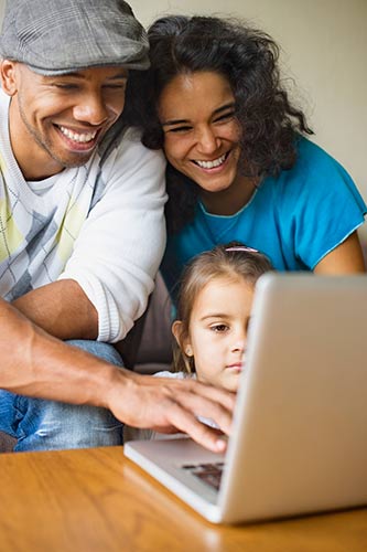 Parents looking for family life insurance plans on their laptop