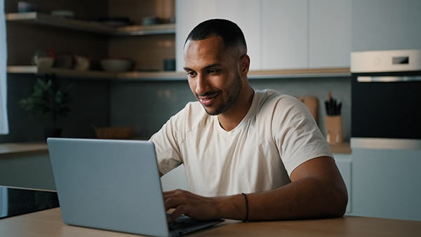 Man looking up information about a type of life insurance on his laptop